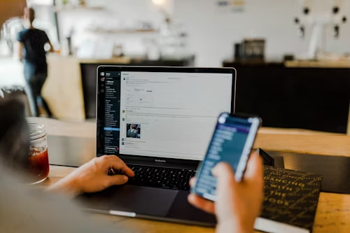 An employee holding his phone while slack is open
