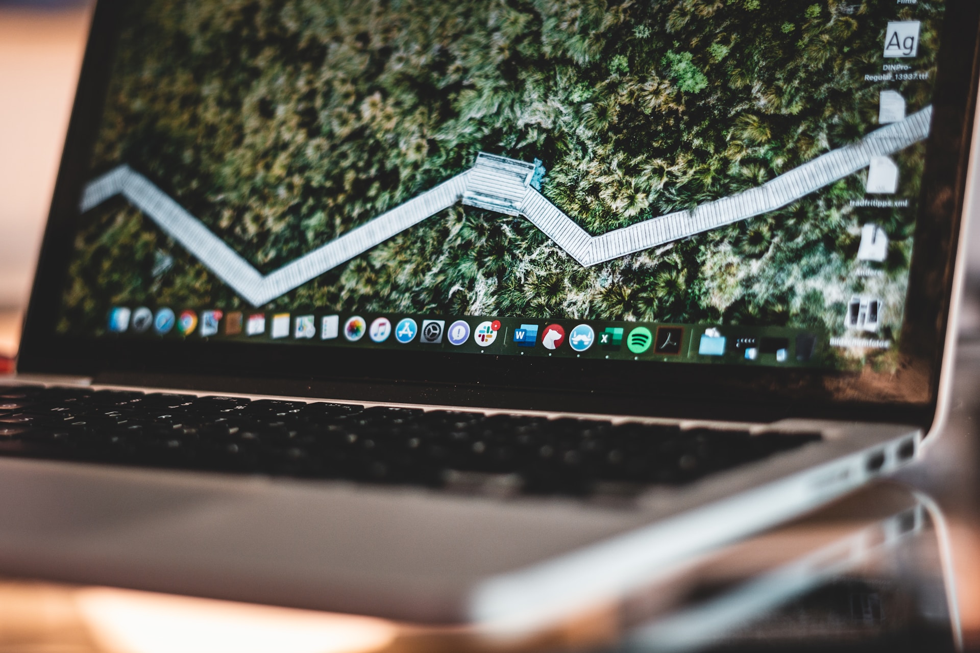 A laptop displays icons at the bottom