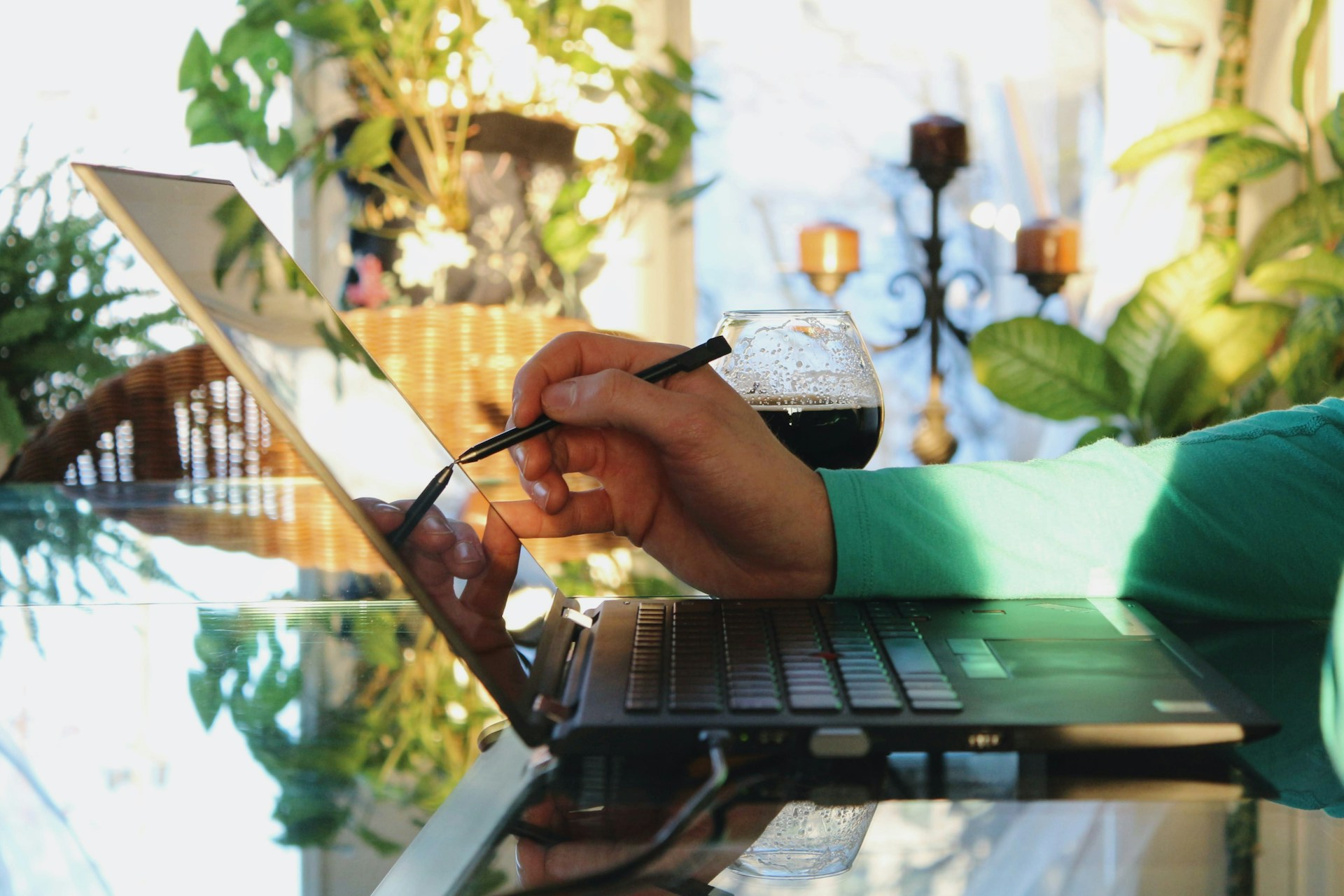 A person writing on the laptop display