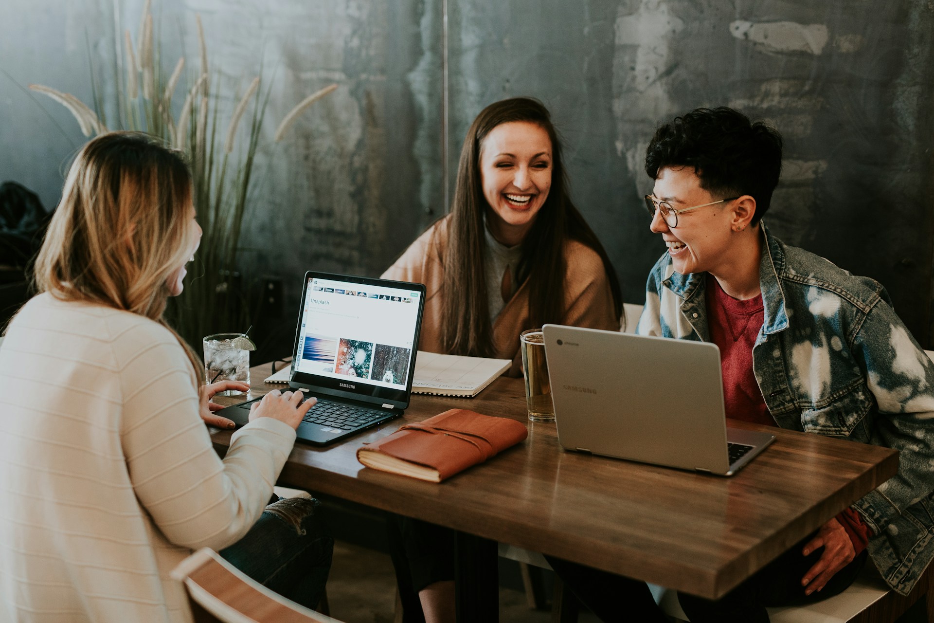 Three people sitting in front of their laptops
