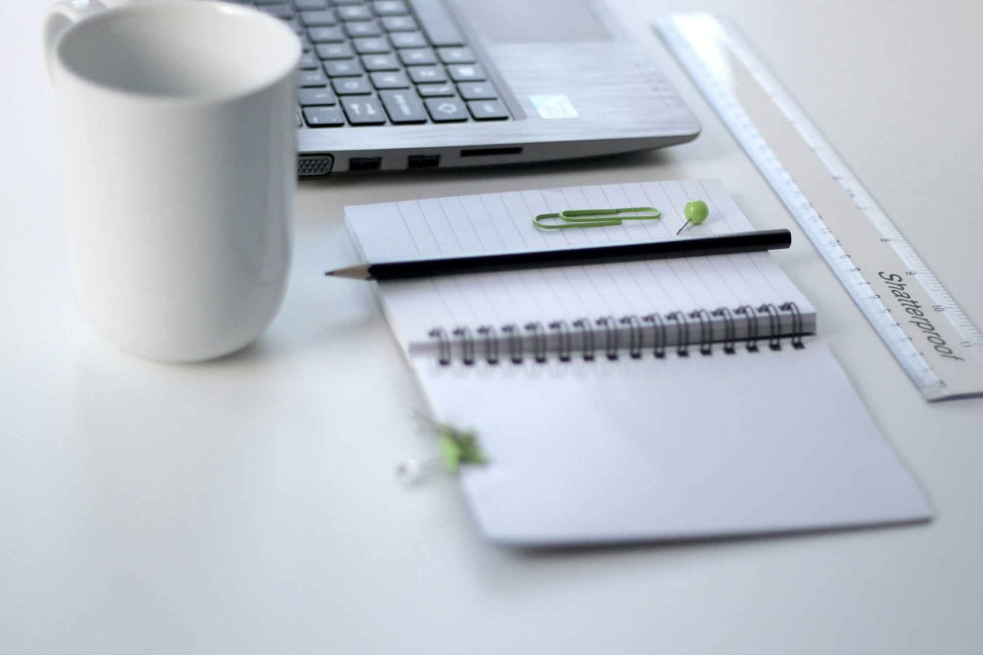A pencil and a notebook beside a laptop